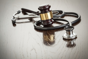 Gavel and Stethoscope on Reflective Table