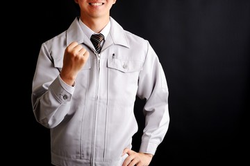 ガッツポーズをする作業服の男性