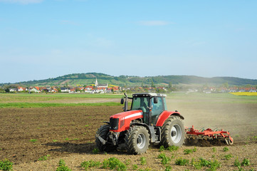 Obraz premium Traktor auf dem Feld bei der Arbeit