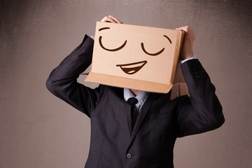 Businessman gesturing with a cardboard box on his head with smil