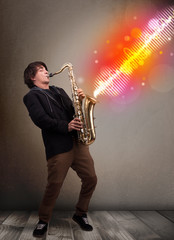 Young man playing on saxophone with colorful sound waves