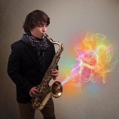Attractive musician playing on saxophone with colorful abstract