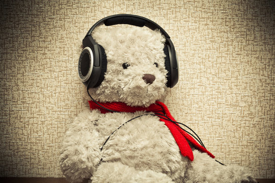 retro bear listening to music on headphones. photo toned yellow