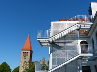 Fluchttreppe der Grundschule Helpup vor blauem Himmel im Sonnenschein mit Kirchturm bei...