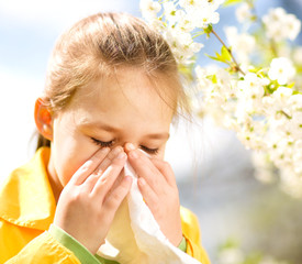 Little girl is blowing her nose