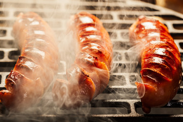 Grilling sausages on barbecue grill