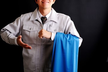工芸品を持っている作業服の男性