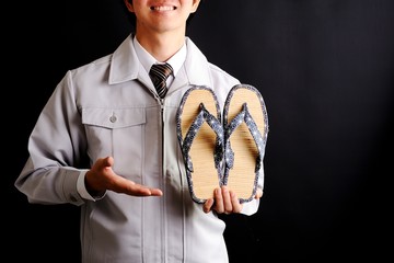 工芸品を持っている作業服の男性