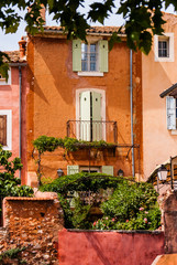 Fototapeta na wymiar Orange stone buildings with lush garden in France.