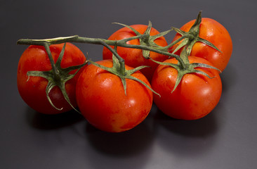 Red tomatoes on a black background