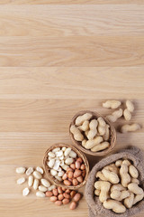 Peanuts in the bag sack with empty space on wooden background