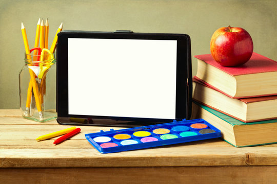 Back to school concept with tablet, books and apple