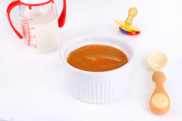 Baby food and milk isolated on white
