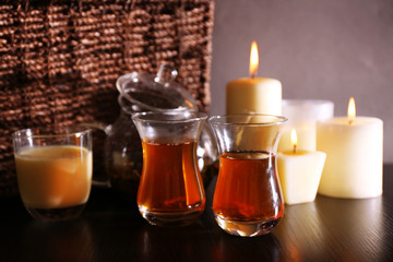Composition with tea in glass teapot and candles