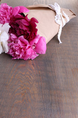 Bouquet of beautiful peonies on wooden background