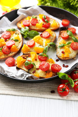 Tasty bruschetta with tomatoes in pan, on table