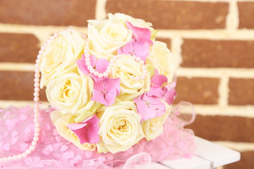 Beautiful wedding bouquet with roses on bricks wall background