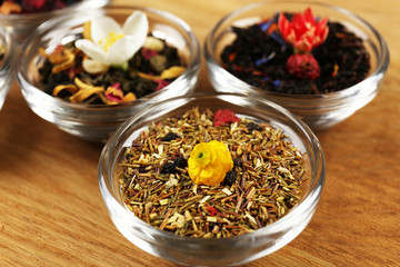 Assortment of dry tea on wooden table, close up