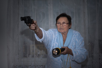 Senior woman with a gun and torch