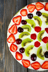 Homemade sweet pizza with fruits on wooden table, close up