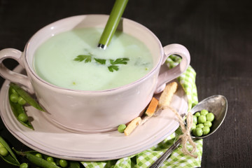 Tasty peas soup on wooden table with dark light