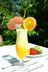 Delicious fruit smoothie on white table, outdoors