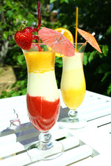 Delicious fruit smoothie on white table, outdoors