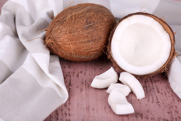 Broken coconut with napkin on wooden background