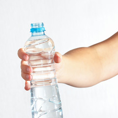 Female hand holding a bottle of fresh water