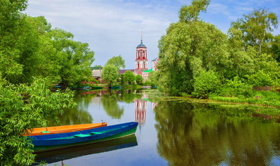 Russian landscape with river, boats and church