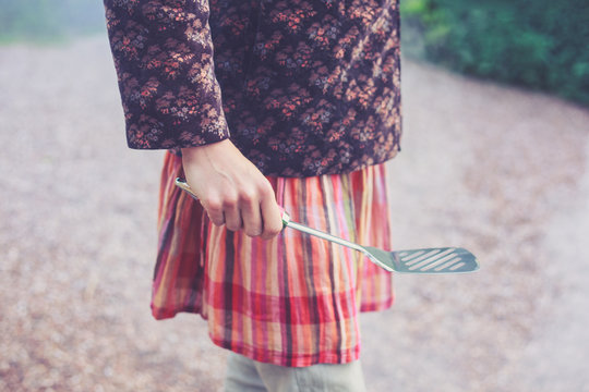 Young woman holding a spatula