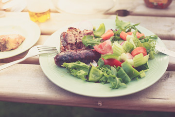 Meat and salad outdors on table