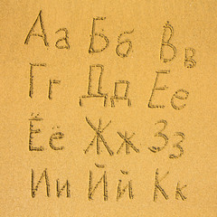 Russian alphabet (A-K) written on a sand beach.