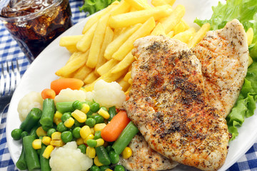 Chicken grilled fillet in herbs with fresh vegetable and fries