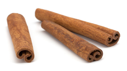 cinnamon sticks stacked on white background
