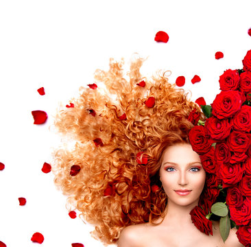 Beauty woman with long curly red hair and beautiful red roses