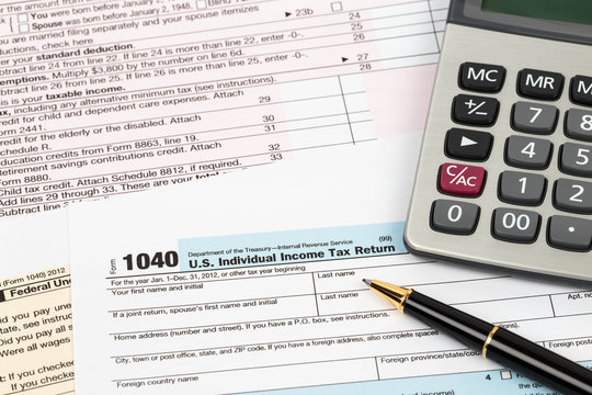 Tax form with pen and calculator taxation concept
