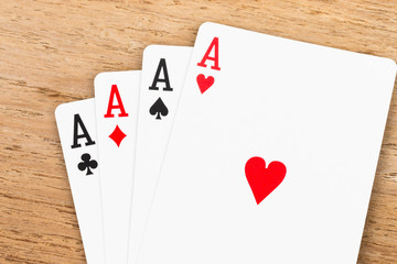 Four aces on wooden background