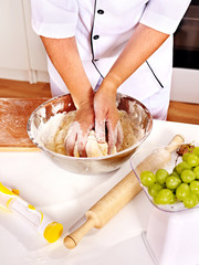 Female hand kneading dough.