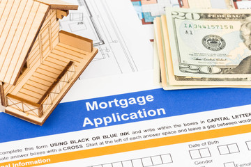 Mortgage application with model house, banknote, and drawing