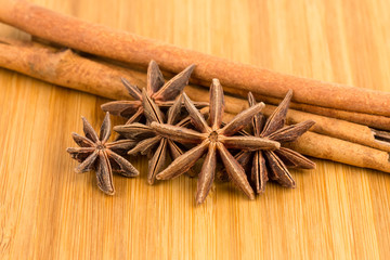Anise stars and cinnamon stick on wooden board