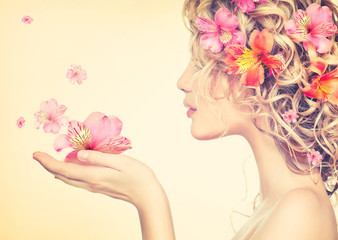 Girl takes beautiful flowers in her hands. Blowing flower