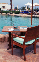 Table and chairs near swimming pool