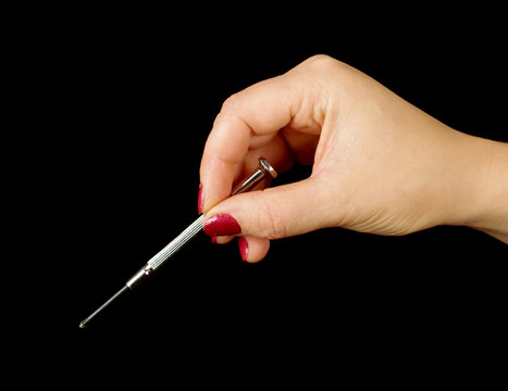 Female hand holding small philips screwdriver