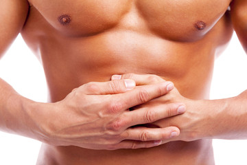 Muscular man having stomach pain, isolated on white background