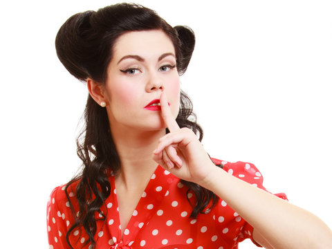 Retro. Pinup girl with finger on lips asking for silence