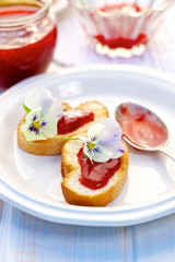 Toasts with homemade strawberry jam and edible flowers