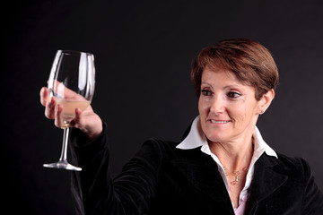 pretty old woman rising up a glass of wine (focus face)