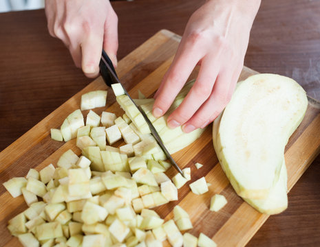 Female hands cutting the eggplant