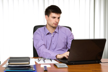 Fototapeta premium Young handsome businessman working on laptop